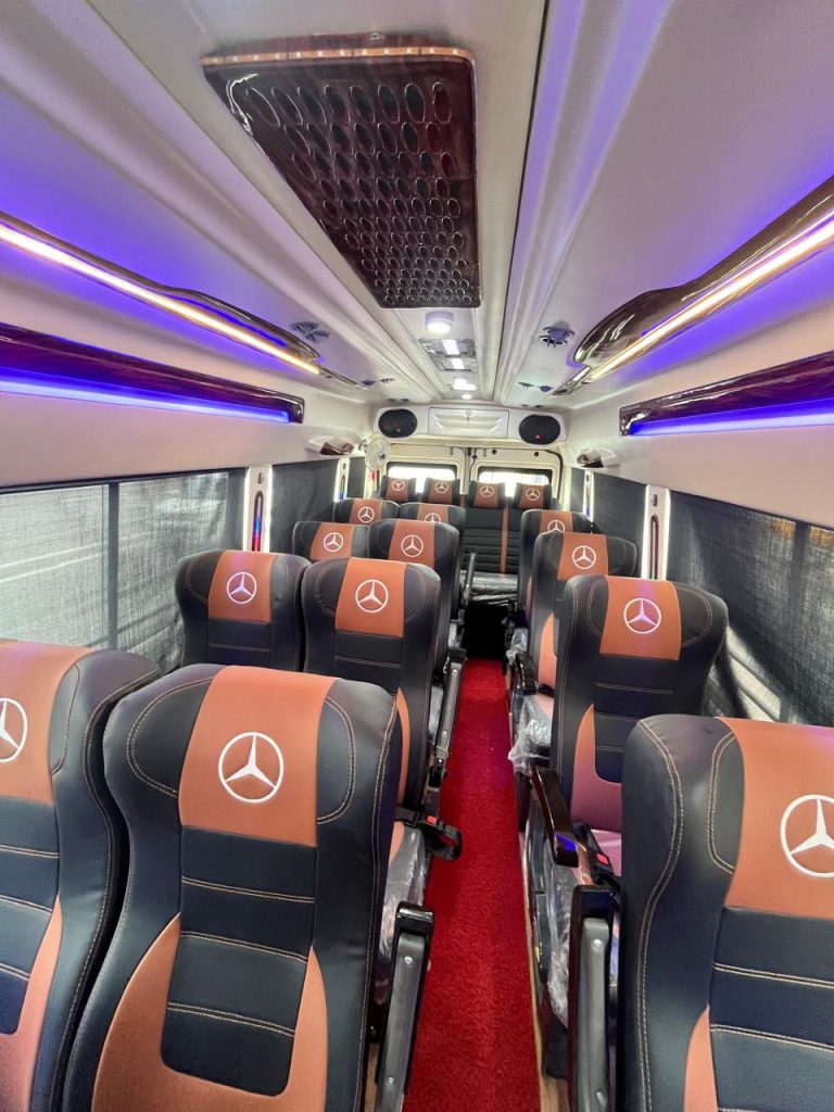 AC Tempo Traveller interior with black and brown push-back seats and LED ceiling lights
